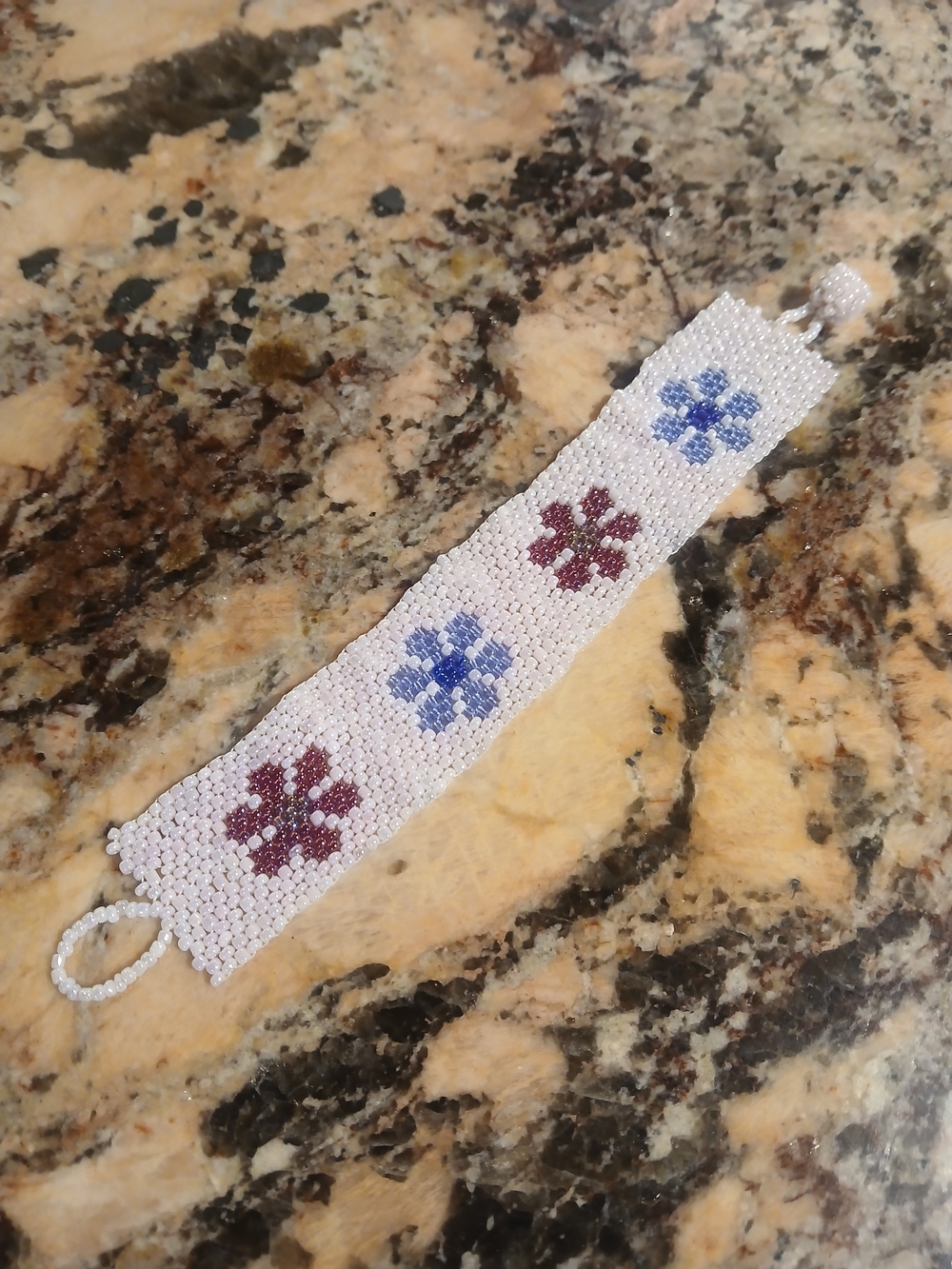 Hand Crafted White Beaded Bracelet with Blue and Purple Flower Motifs